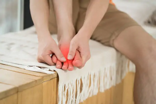 Foot pain, man suffering from feet ache at home, podiatry concept